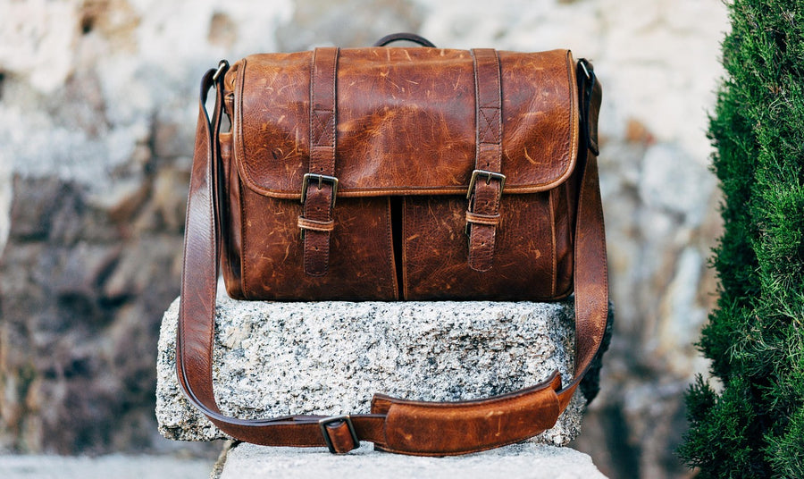 Tan leather handbag resting on a neutral surface
