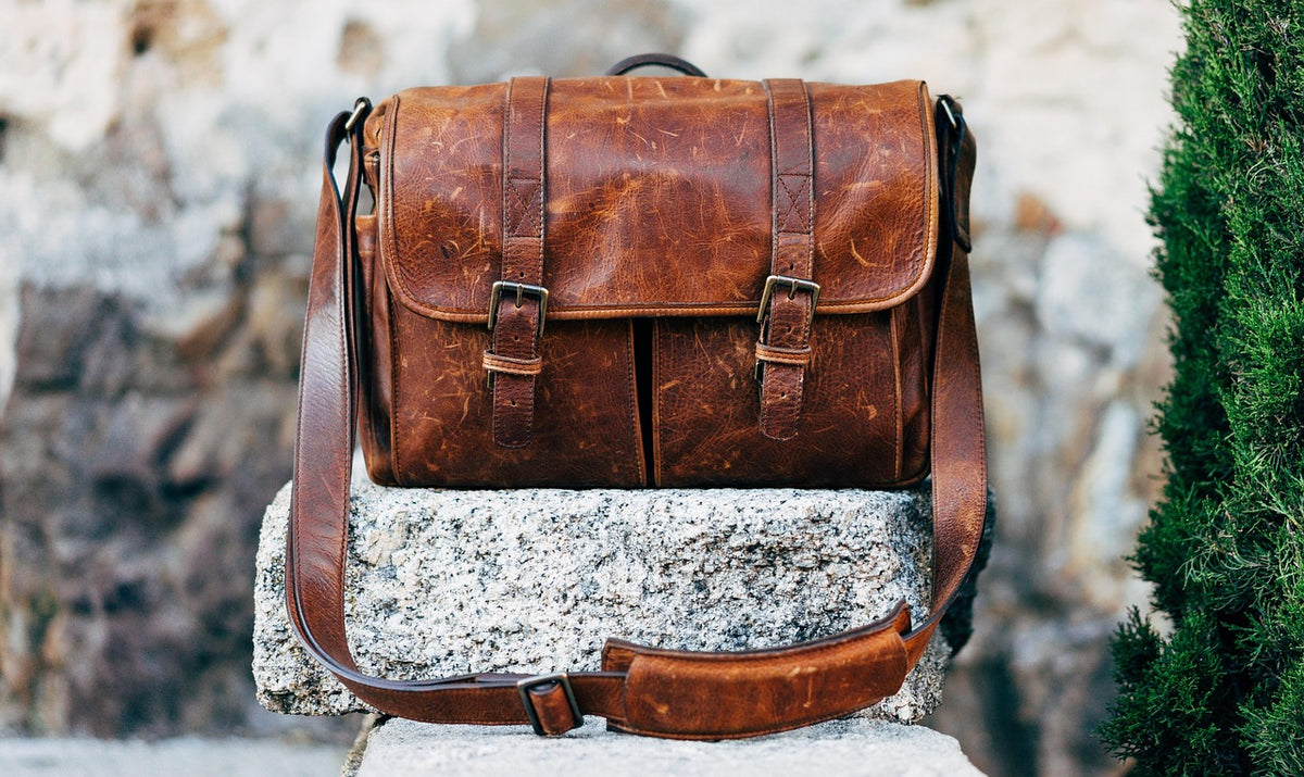 Tan leather handbag resting on a neutral surface